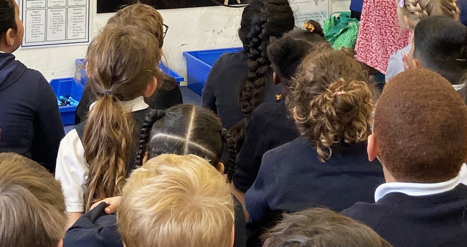 Kids watching Kirstin McNeil at a school presentation